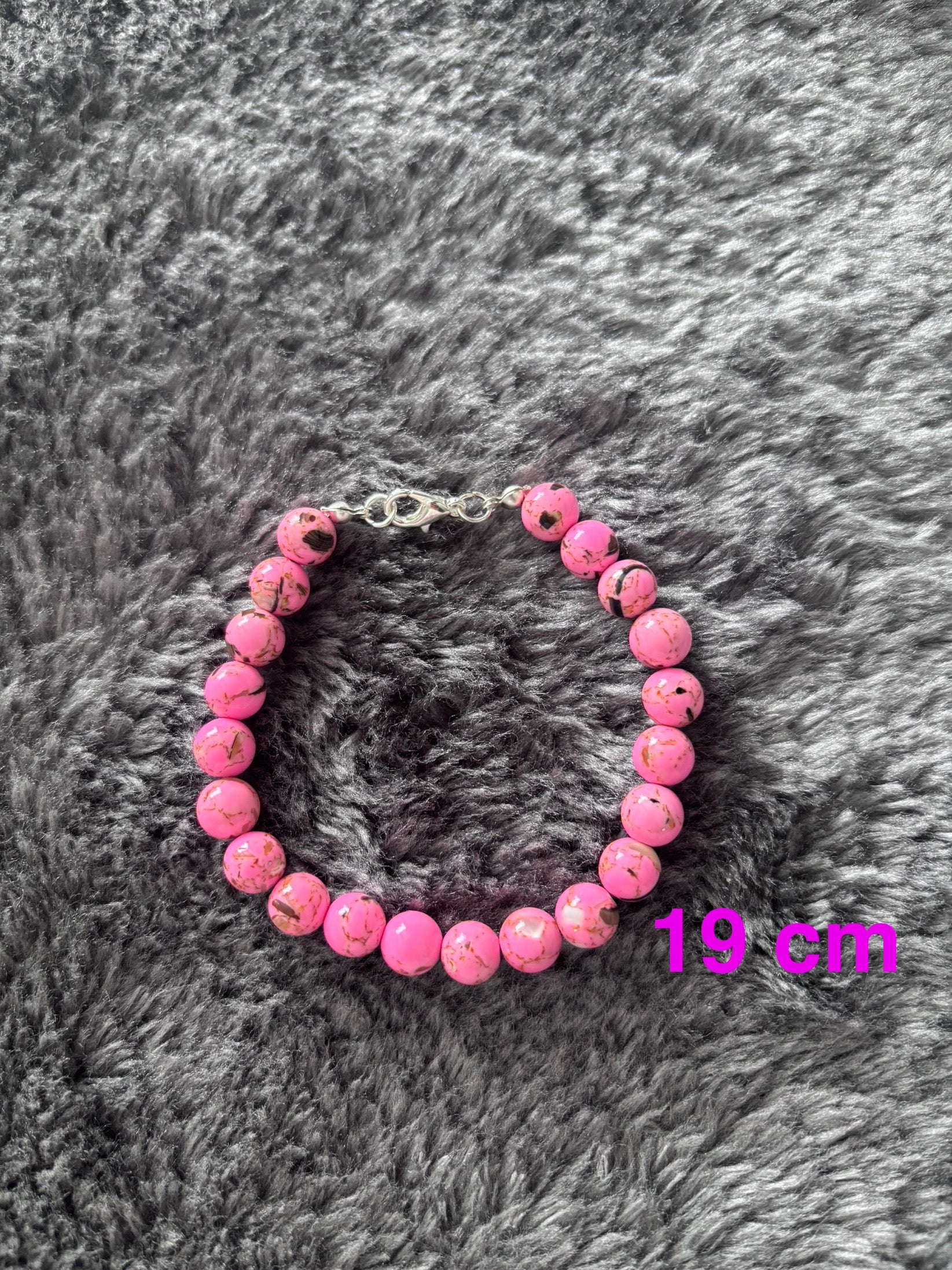 Handgemaakte roze glas kralen armband van 19 cm met marmerpatroon op grijze achtergrond 