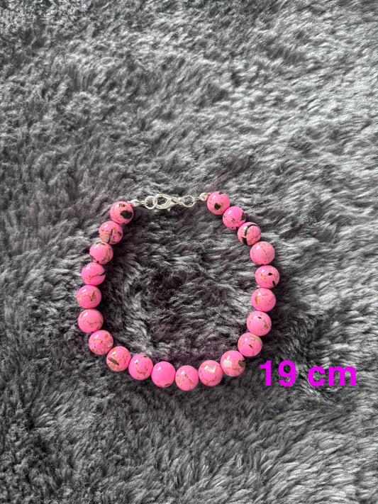 Handgemaakte roze glas kralen armband van 19 cm met marmerpatroon op grijze achtergrond 