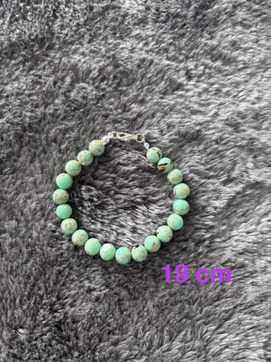 Handgemaakte armband van turquoise glas kralen met marmer effect ,19 cm lang.