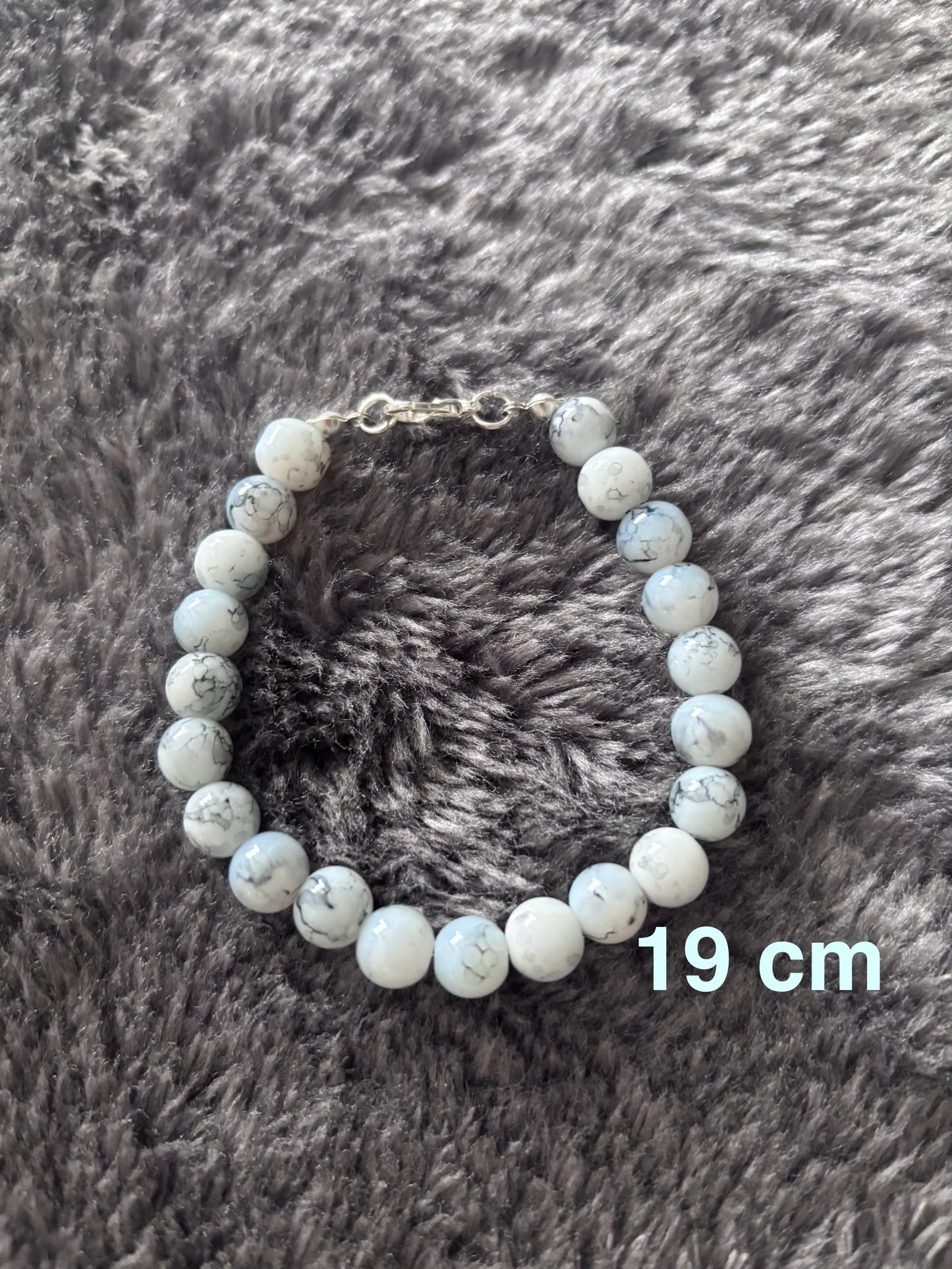 Handgemaakte armband van witte glas kralen met grijs marmer-effect, 19 cm lang.