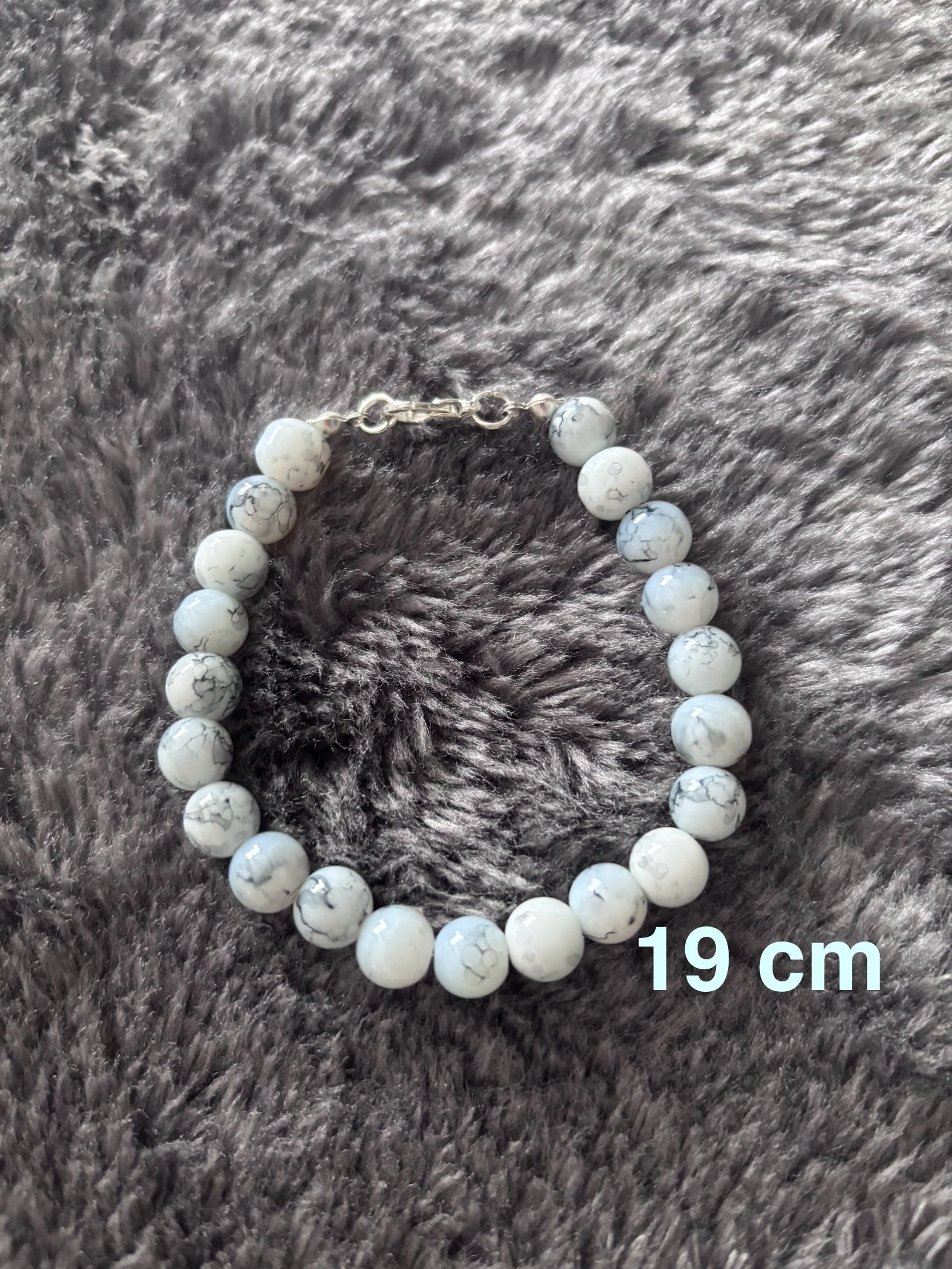 Handgemaakte armband van witte glas kralen met grijs marmer-effect, 19 cm lang.