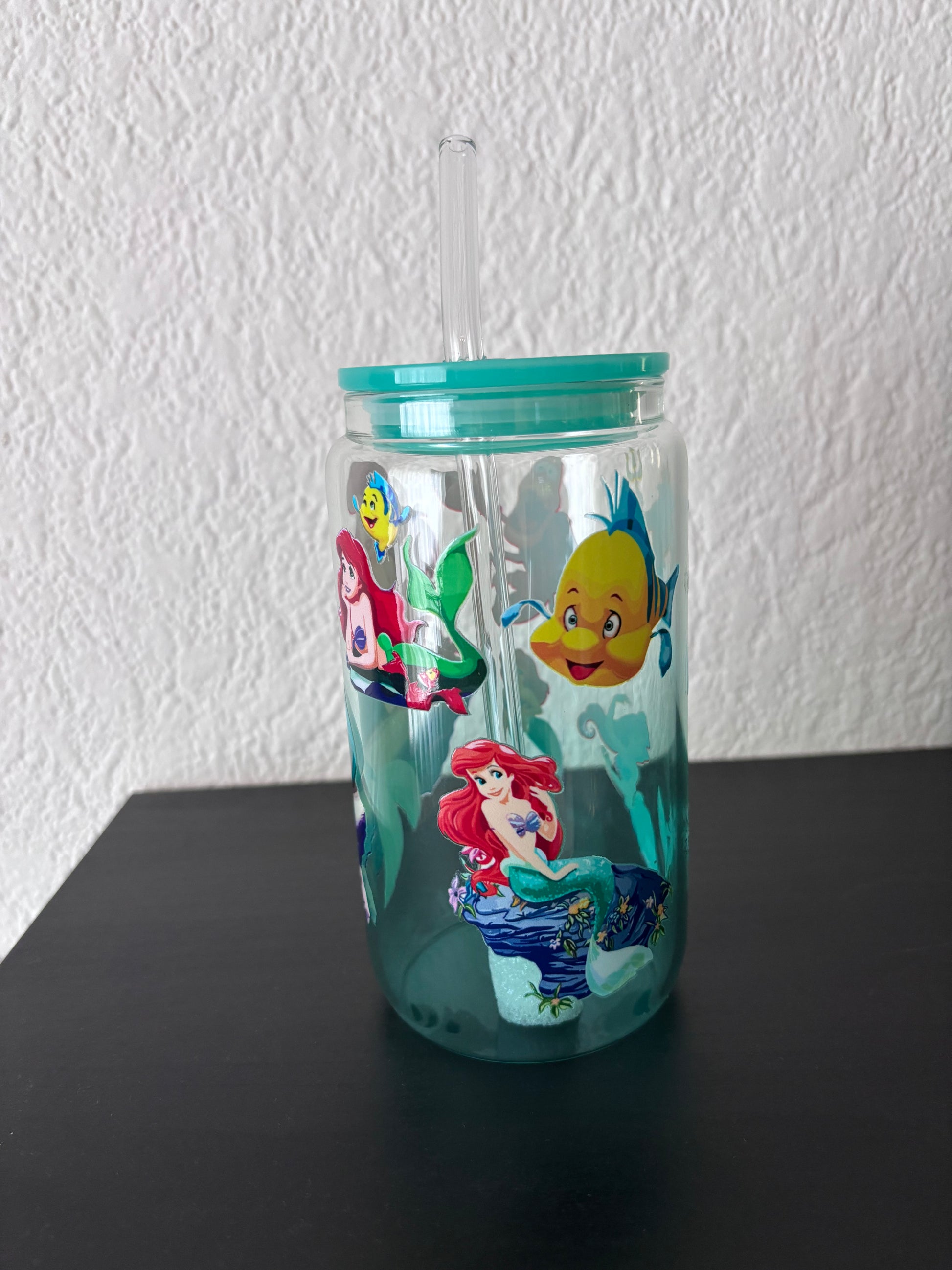 2️⃣ Beker met illustratie van een roodharige zeemeermin en vrolijke zeedieren op een lichtblauwe achtergrond.
